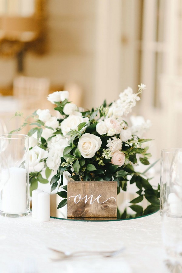 simple white and green wedding centerpiece with wood table number