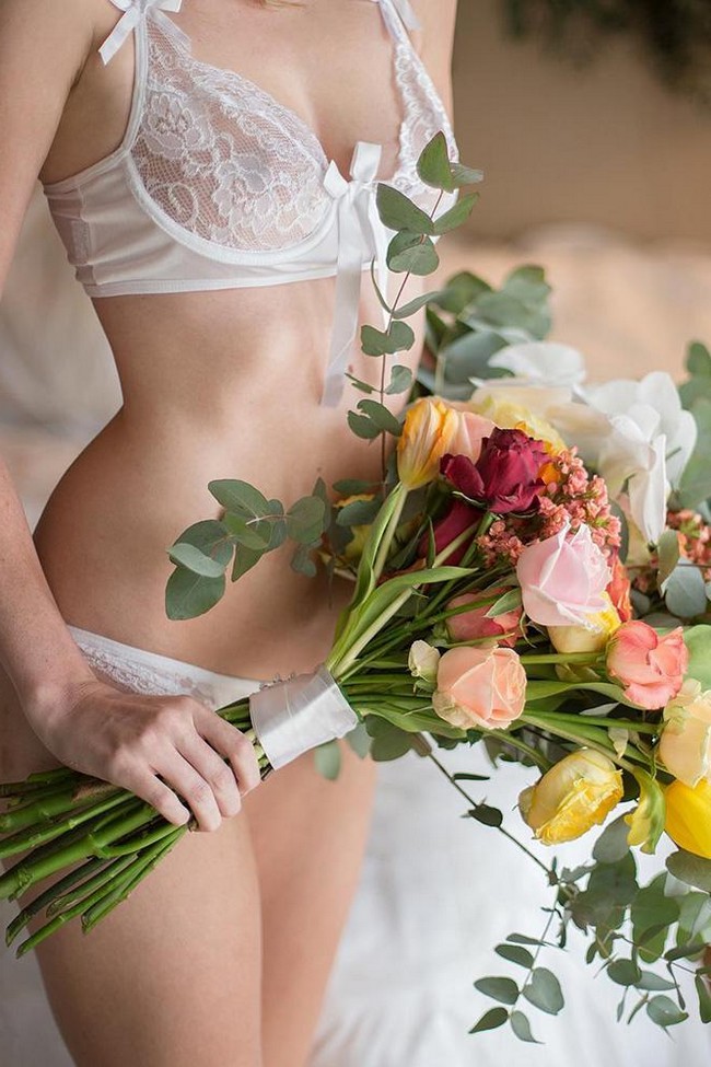 wedding boudoir book the bride in white lace lingerie holds a bouquet bridalboudoir via instagram